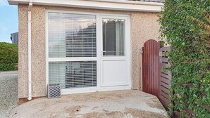 Une maison avec un toit en tuiles, un grand portail de garage et un portail en bois.