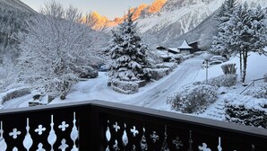 Eine verschneite Berglandschaft mit einer Straße, die zu einem Gebäude führt.
