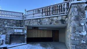 Ein Steinhaus mit Holzbalkon und einem Schild, das Parkplätze anzeigt.