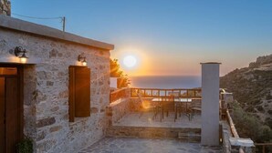 A stone building with a terrace overlooking a scenic view.