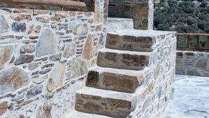 A stone staircase with a wooden railing, leading up a hill with a view of a mountainous landscape. - Cozy Studio Plagia Room 3 (Plagia)