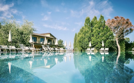 Una piscina al aire libre de temporada, sombrillas