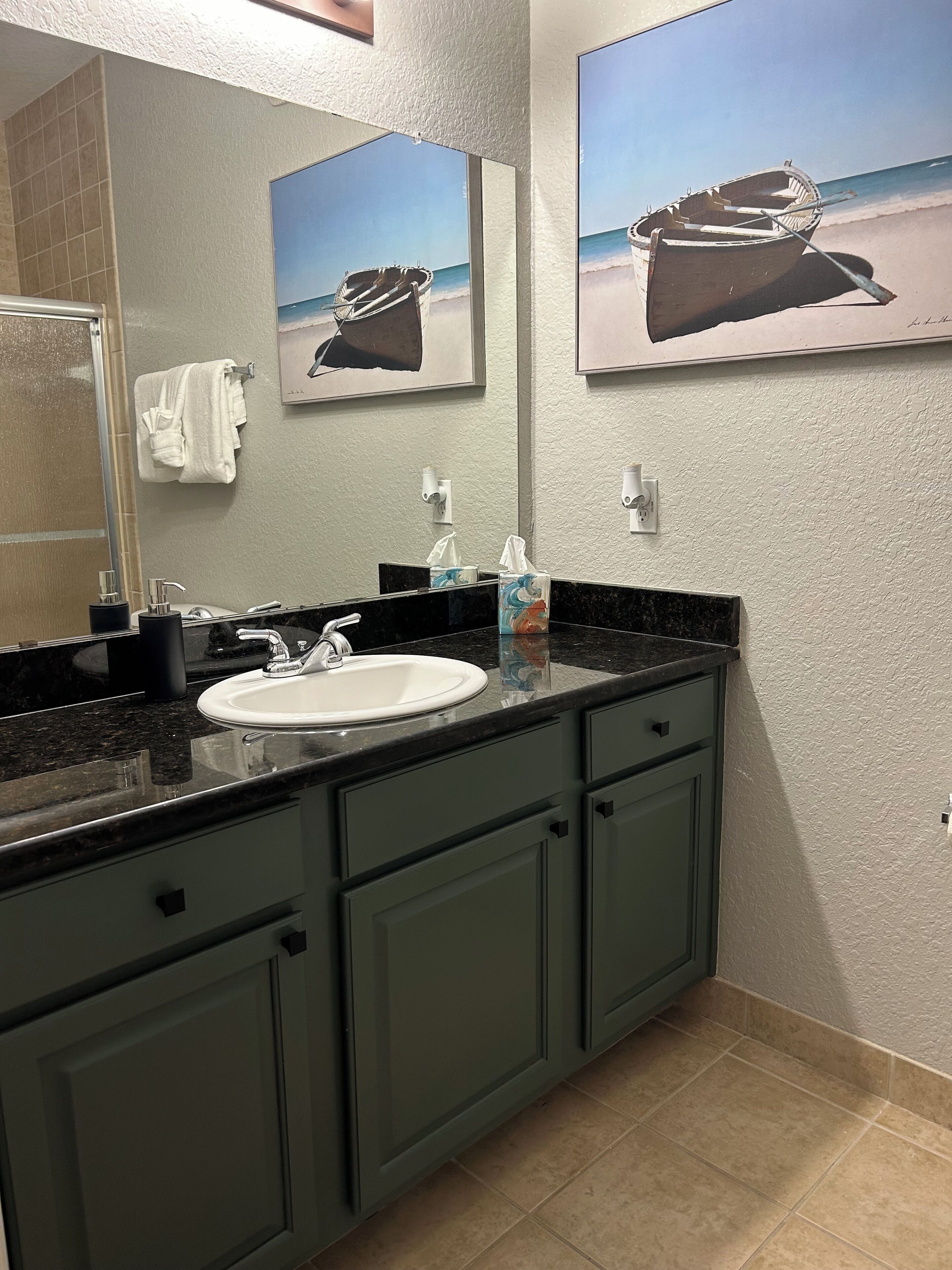 A modern bathroom with a large mirror, a sink, and a towel rack.