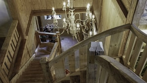 A wooden staircase with a chandelier, wooden walls, and a stone floor. - La Ferme Authentique Ferme Rénovée, Dans un Cadre Champêtre (Praz-sur-Arly)