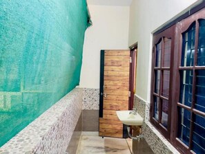 Stylish hallway with a circular tile floor, green accent wall, and a door leading to an adjacent room.