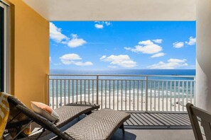 Un balcón con mobiliario de mimbre con vista a la playa.