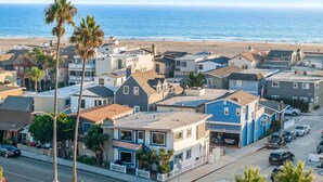Une zone résidentielle côtière avec des maisons, une plage et un ciel dégagé.