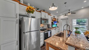 Una cocina moderna con electrodomésticos de acero inoxidable, encimera de granito y horno integrado.