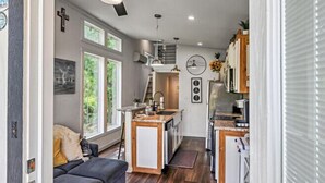 Una cocina moderna con una isla central, una zona de comedor con sofá y un ventilador de techo.