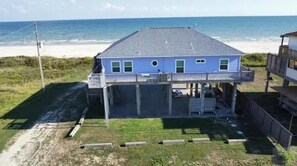A two-story house with a balcony, located near a beach. - Beachfront Living! Multi-Generation Beach Home with 360 Water Views (Bolivar Peninsula)