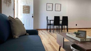 Un salon comprenant un canapé, une table basse et un coin repas avec des chaises et une table.