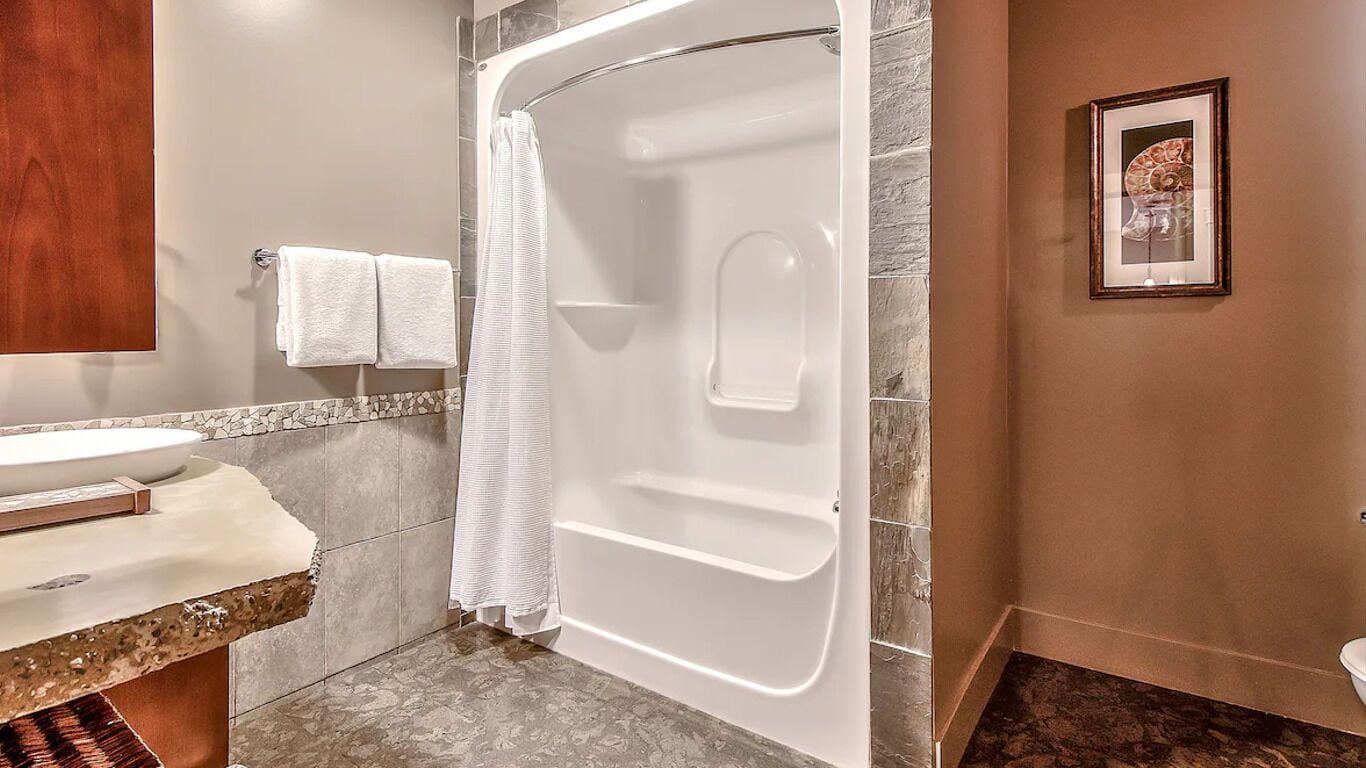 A modern bathroom with a bathtub, a sink, and a shower curtain.