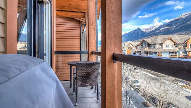 Un balcon offrant une vue sur une montagne et des maisons traditionnelles.