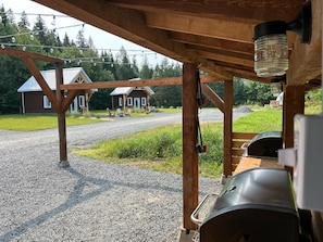 Un espacio al aire libre cubierto con un sendero de grava que lleva a un edificio con techo de metal.