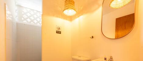Une salle de bain équipée de toilettes, d’un lavabo et d’une douche.