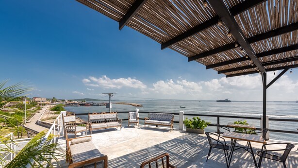 An outdoor patio with seating and a view of the sea.