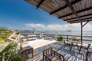 Een terras buiten met zitplaatsen en uitzicht op zee.