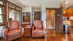 A spacious room with two leather chairs, a wooden table, and a large window. - Private Hot Tub, Walk to Main St, Close to Ski Resorts, Incredible Views (Firsco)