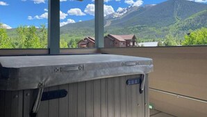 A hot tub under a covered balcony with a view of mountains and houses. - Private Hot Tub, Walk to Main St, Close to Ski Resorts, Incredible Views (Firsco)