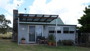 A single-story house with a covered patio, a sliding glass door, and a sign reading "The Cottage." - Twodogfolly at Dangarsleigh, Cottage at Dangarsleigh (Armidale)