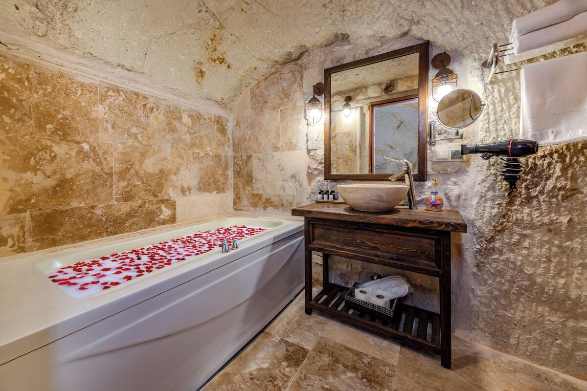 A bathroom with a bathtub, a sink, a mirror, and a towel rack.