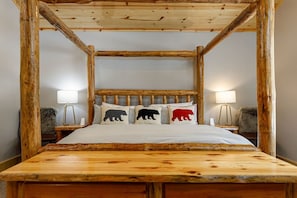 Un lit à baldaquin avec un cadre en bois et un couvre-lit blanc.