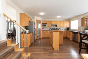 A modern kitchen with wooden cabinets, stainless steel appliances, and a central island.