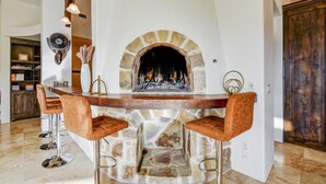 A stone fireplace with a bar counter and two bar stools in front. - Boerne Hacienda with Pool and Spa (Boerne)