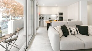 A modern apartment with a living area, kitchen, and dining space.