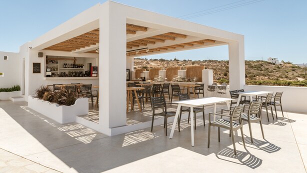 Eine Außenpatio-Terrasse mit Bar, Sitzgelegenheiten und Blick auf die Landschaft.
