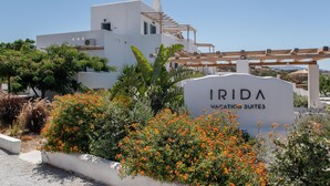 Een modern gebouw met een bord waarop 'IRIDA VACCINATION SUITES' staat.