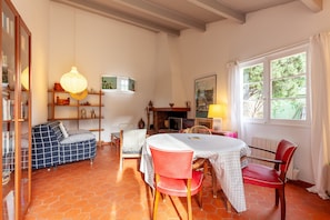 A cozy room with a sofa, dining table, chairs, and a fireplace. - Holiday Home 'Lou Jas - Cassis' with Private Terrace and Wi-Fi (Cassis)