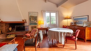Een gezellige woonkamer met een open haard, een eettafel en comfortabele zitplaatsen.