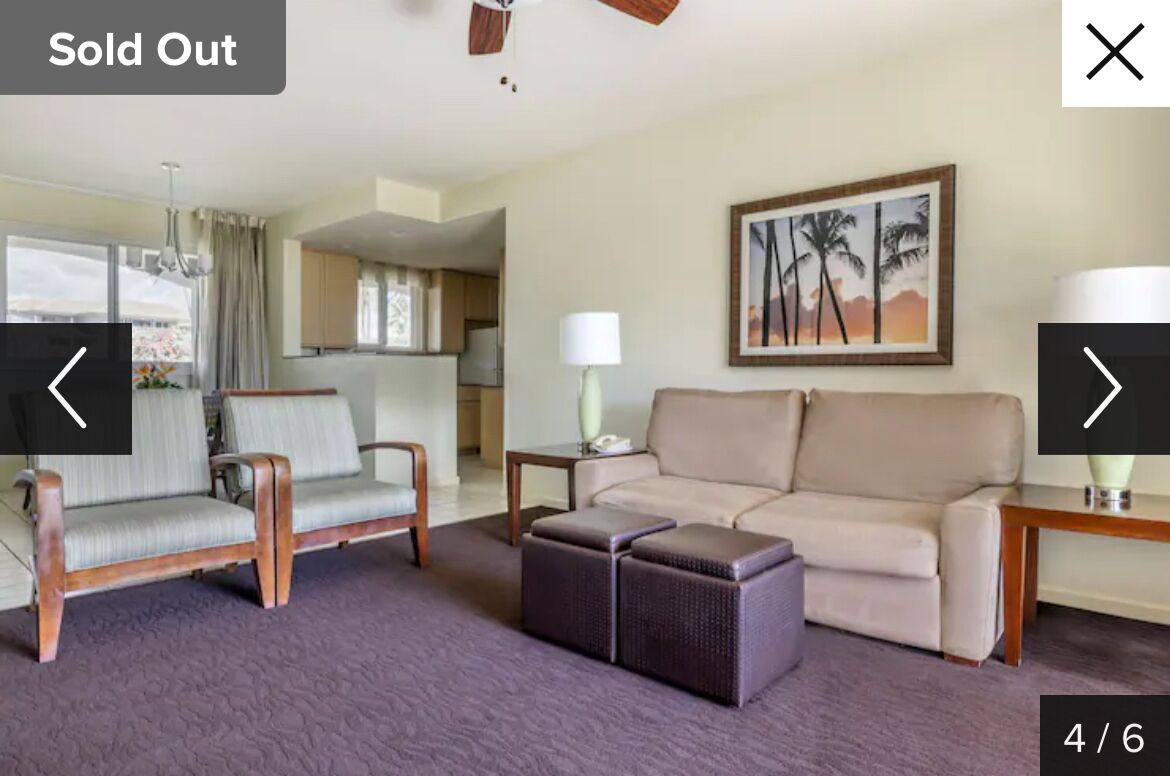 A living room with a sofa, two armchairs, a coffee table, and a painting on the wall.