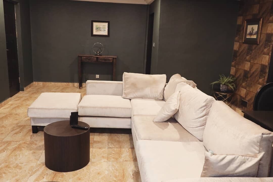 A modern living room with a sectional sofa, a small side table, and a dark round coffee table.