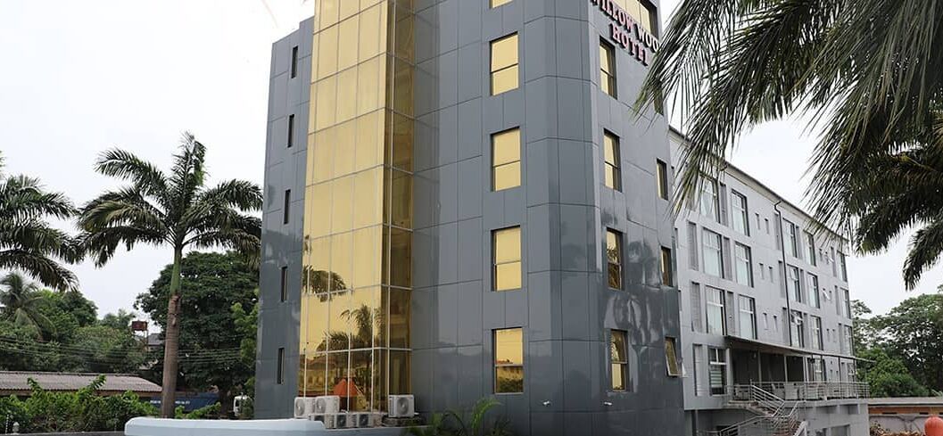 A modern hotel building with a reflective glass facade, multiple windows, and a flat roof.