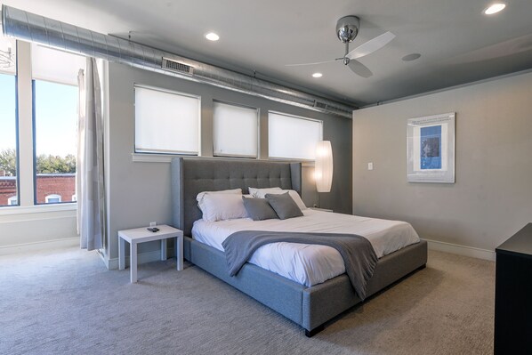 Ein Schlafzimmer mit Bett, Nachttisch und Deckenventilator.