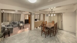 A spacious living area with a dining table and chairs, a sofa, and a TV. - La-Rivière: 3-bedroom family-sized house (Lal-lo)