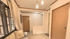 A hallway with a sofa, a door, and a staircase. - La-Rivière: 3-bedroom family-sized house (Lal-lo)