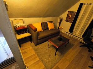 Un salon comprenant un canapé, une table basse, un banc et une petite table sur laquelle est posée une plante.