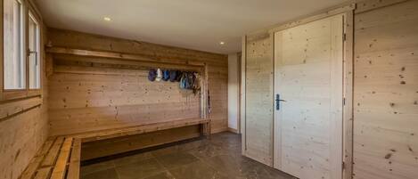 A room with a wooden bench, a tiled floor, and a wardrobe with a door.
