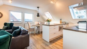 Un appartement moderne comprenant un coin repas, une cuisine et un salon.