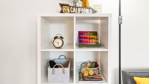 A white shelf with a Route 66 sign, a clock, a book titled 'COACHELLA', a woven bag, and a decorative item with yellow flowers.