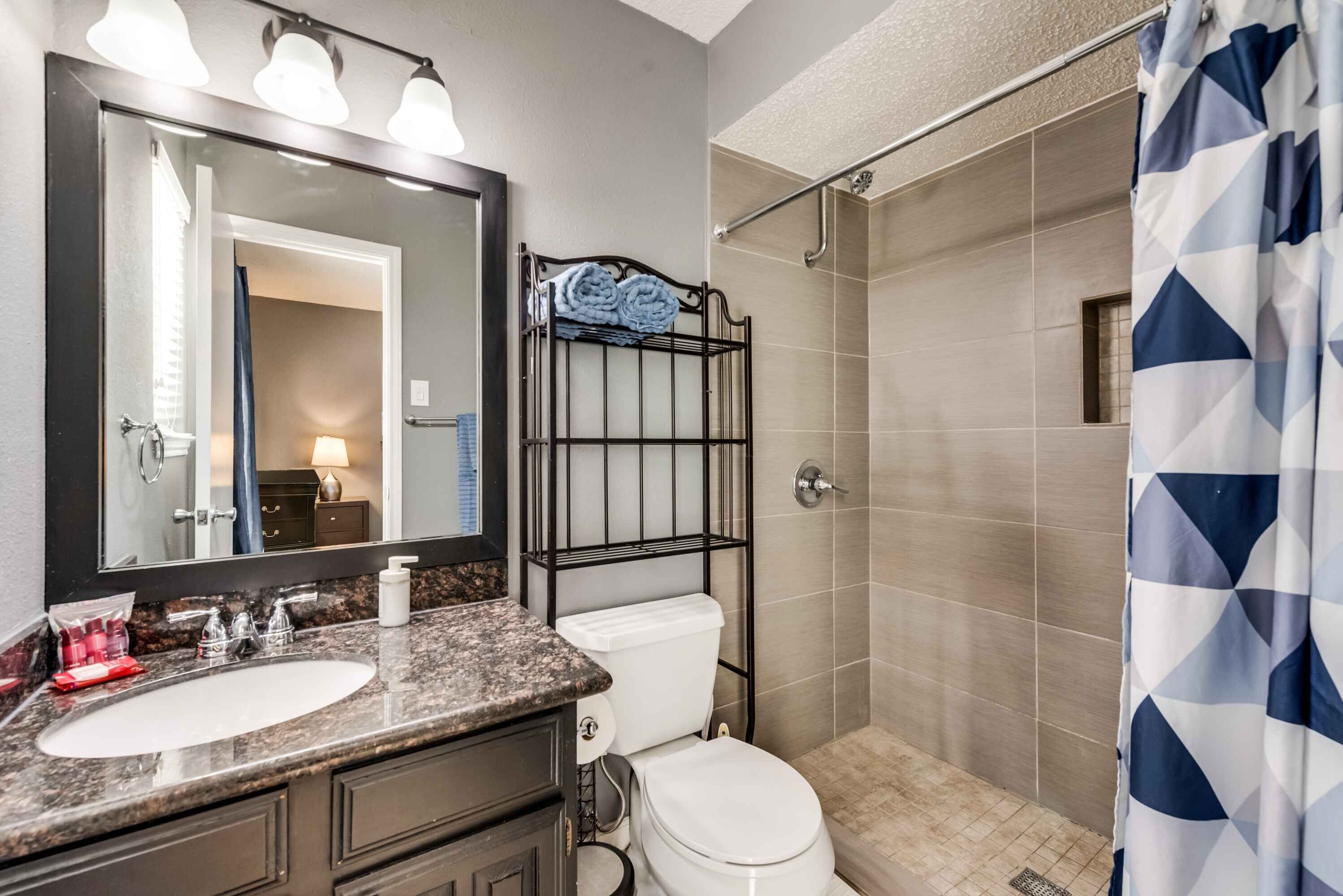 A bathroom with a sink, toilet, and shower.