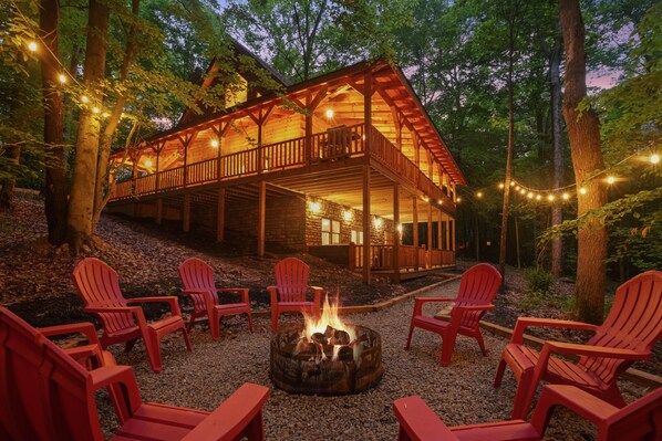 A wooden cabin with a deck and outdoor seating area.
