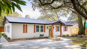 A single-story house with a gabled roof, white siding, and wooden shutters. - Cozy Home Near Folly Field Beach (Hilton Head Island)