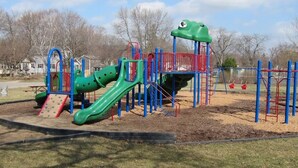 A playground with a slide, climbing structures, and a frog-themed play area. - Downtown Home Away from Home 3BR/3BA (Rochester)