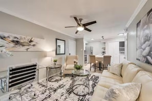 Un salon moderne avec un canapé, une table basse et un ventilateur de plafond.