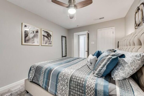 A bedroom with a bed, a ceiling fan, and two framed pictures on the wall. - I32 - Apt|Patio|11mi to Convention Ctr|Sleeps 2 (Irving)