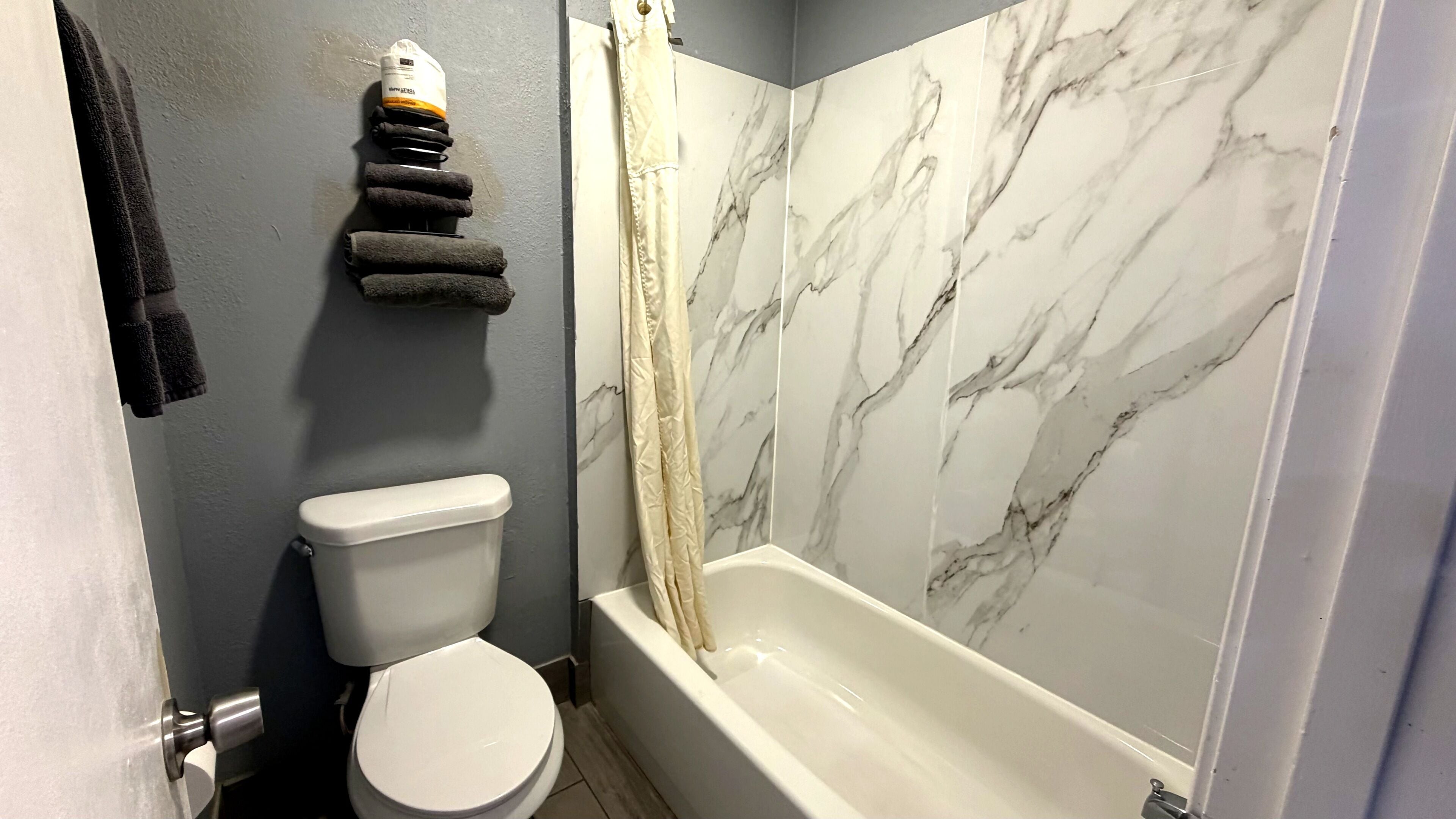 A bathroom with a toilet, a bathtub, and a shower curtain.